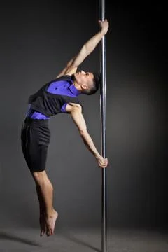 Pole dance man over black background with flashes Stock Photos