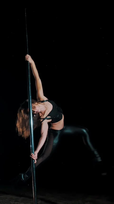 Pole dance. witch halloween. fit female gymnast, in black leather outfit and Video stock 314455475