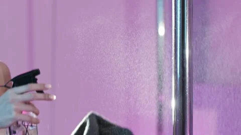 Pole dancer cleaning and disinfecting metal pole in gym Stock Footage 304950397