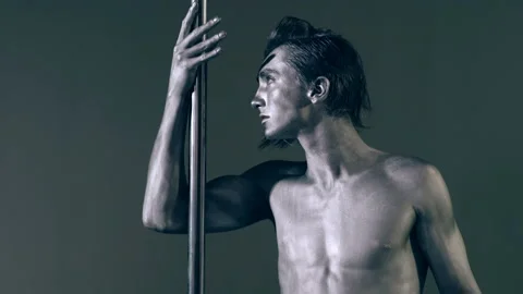 Pole dancer. Guy does gymnastic exercises on pole dance. Pole dancing for slim Stock Footage 321386170