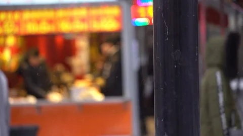 Pole in focus as people walk by in snowfall. China, Shenyang 스톡 동영상 84434703