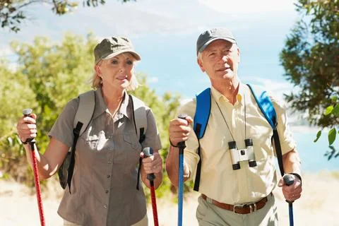 Pole, hiking and explore with old couple in nature for bonding, adventure or Foto stock