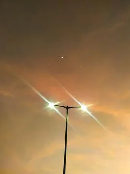 Pole lights burning at sunset Stock Photos
