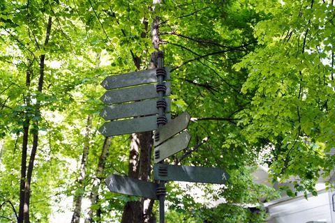 Pole with metal pointers of various directions and a figure of a person Stock Photos