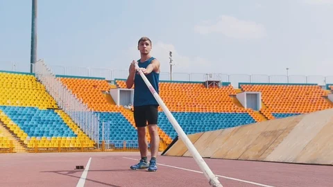 Pole vault - an athletic man raises the pole before running up Stock Footage 114164860