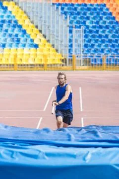 Pole vault - a bearded athletic man runs up holding a pole before jumping. Foto stock