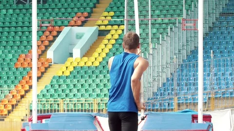 Pole vault - a young man prepares to runs up holding a pole Stock Footage 113456288