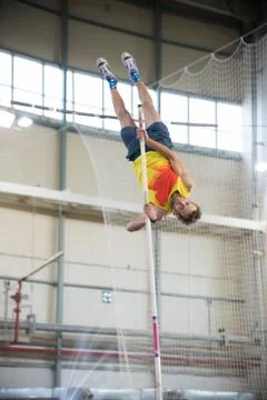 Pole vaulting - man with beard is reaching the bar on the pole Foto stock