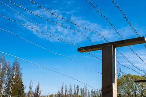 Poles with barbed wire at the state border and observation tower Stock Photos