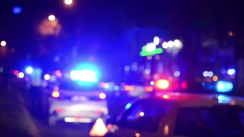 Police, ambulance and firetrucks lights flash at night. Crime scene. Blurry Stock Footage