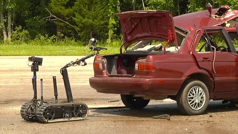 Police and army troops use a remote control robot to diffuse a bomb in a car. Video stock 123363403