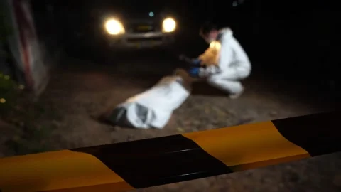 Police and forensics officers are blocking off the area to investigate a murder Stock Footage 232940341