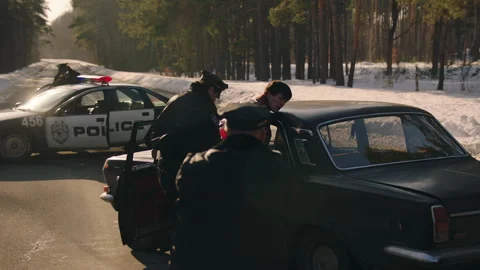 Police arresting a man on the road through the woods Stock Footage 283108135