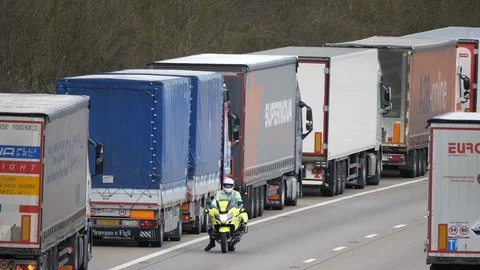 Police bike parking lorries in a queue on the M20 motorway during Video stock 104829456
