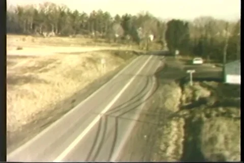 Police car chase the stolen car on Country Road - 1975 Stock Footage