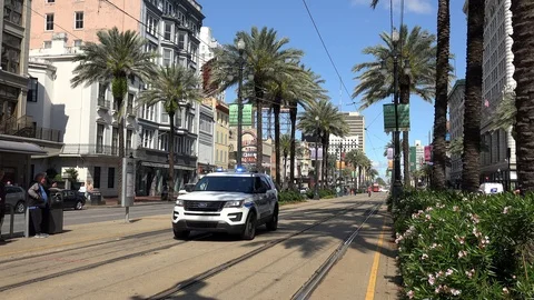 Police car driving at  the Canal Street streetcars line. New Orleans Stock Footage