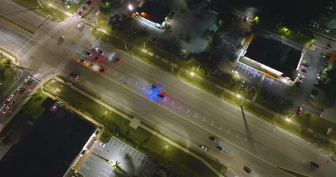 Police car with flashing lights pulled over a speeding vehicle at night on a Vídeos de archivo 324834253