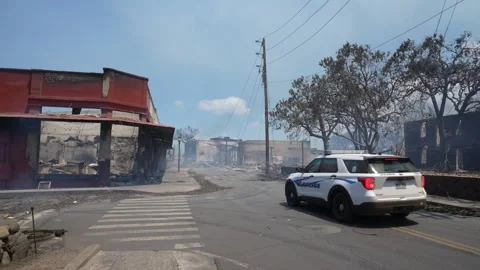 Police Car Pulls Up to remains of Front Street Lahaina Fires Stock Footage 252689973