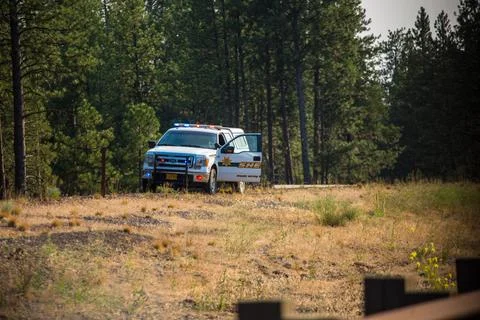 Police car on the side of freeway checking flow of traffic Stock Photos