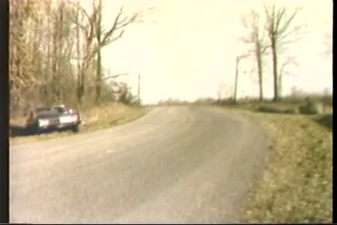 Police chase the stolen car at countryside - 1975 Stock Footage
