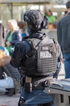 A police commando in a bulletproof vest monitors the situation in the urban.. Stock Photos