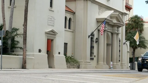 Police cruiser passing St. Augustine Cathedral, Florida, United States. 스톡 동영상 115976858