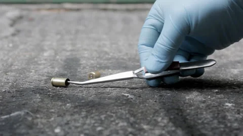 Police CSI retrieving bullet case from street shooting scene Stock Footage 23878735