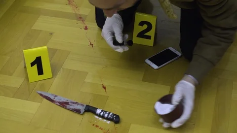 Police detecive using brush and powder to taking fingerprints from handle knife Vidéo 87171126