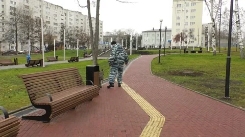 A police dog handler walks with a dog in the park Video stock 163977519