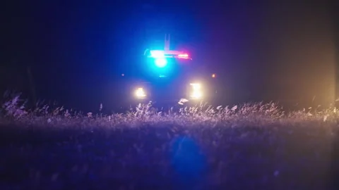 Police lights and headlights glowing night emergency road scene Video stock 342579347