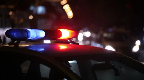 Police lights flashing at night downtown Stock Footage