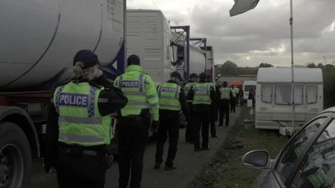 Police lines escorting vehicles delivering to a hydraulic fracturing site, UK Stock Footage 82141061