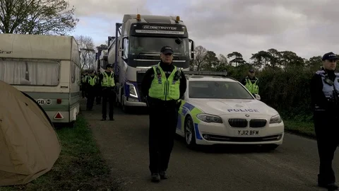 Police lines escorting vehicles delivering to a fracking site, UK Video stock 82275336