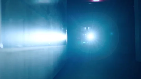 Police man shines flashlight to the camera, patrolling in pitch dark Video stock 248424742