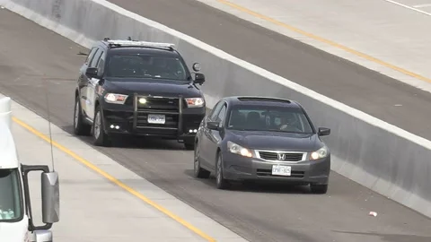 Police officer with car pulled over for traffic violation 库存影片 151063574