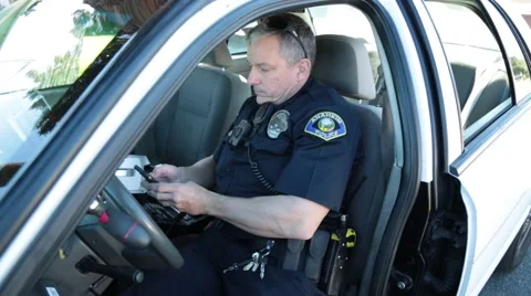 Police Officer checking his cell phone in a patrol car Stock Footage 59165562