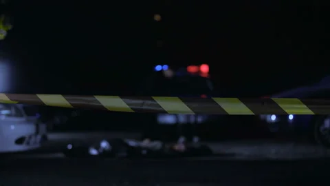 Police officer goes through tape in order to investigate murder crime scene Stock Footage