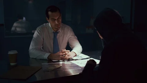 Police officer interrogating a criminal in interrogation room Video stock 106826947