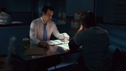 Police officer interrogating a suspect in a dark room Video stock 106824186