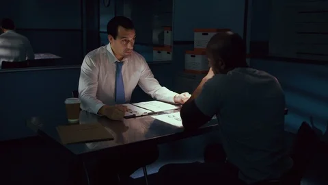 Police officer interrogating a suspect in a dark room Stock Footage 106824842