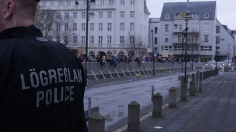 Police officer with protesters in background Stock Footage 61919065