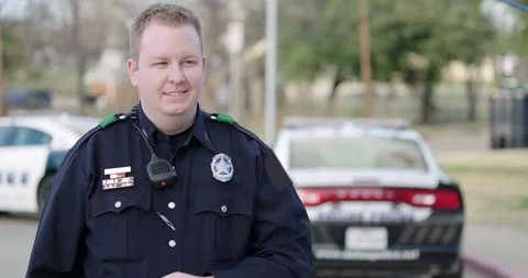 Police officer standing at police car wi... | Stock Video | Pond5