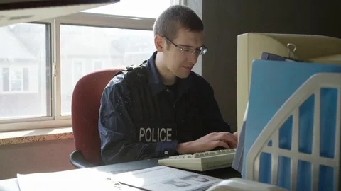 Police officer   work being dropped on his desk Stock Footage 72972154