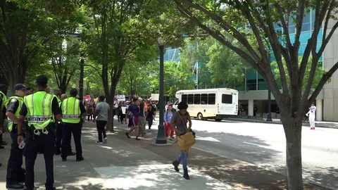 Police officers checking out protesters from a sidewalk in Atlanta Stock Footage 76835892