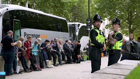 Police officers next to the queue to see Queen Elizabeth ii laying in state Stock Footage 211819828