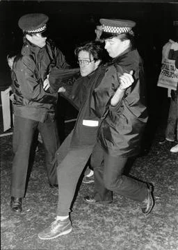 Police Restrain An Angry Protester During The Height Of An Anti-poll Tax Protest Stock Photos