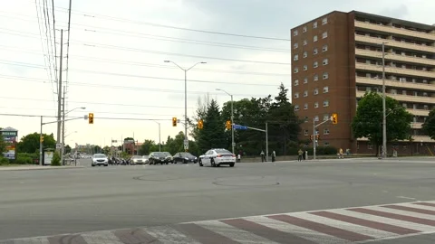 Police reversing while driving back in circle in middle of large intersection Stock Footage 133975573
