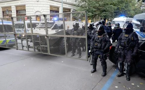 Police in riot gear, along with an armored vehicle in Prague Stock Photos