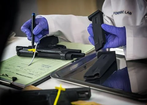 Police scientist notes serial number on sealed firearm in crime lab, concep.. Stock Photos