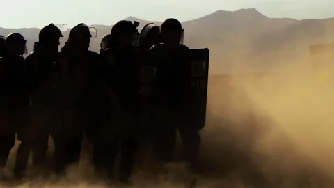 Police with shields and batons lined up in order of battle, dust and sand Video stock 120211672